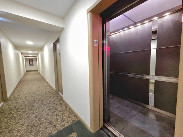 corridor with carpet floors and elevator