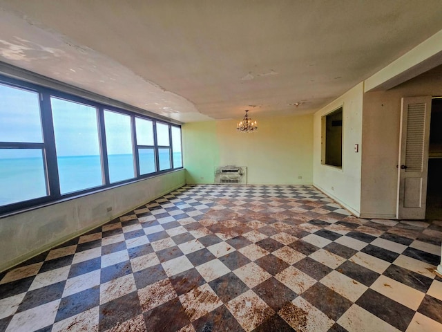 unfurnished room featuring heating unit, an inviting chandelier, and tile patterned floors