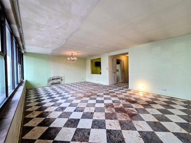 spare room with a chandelier, dark floors, heating unit, and baseboards