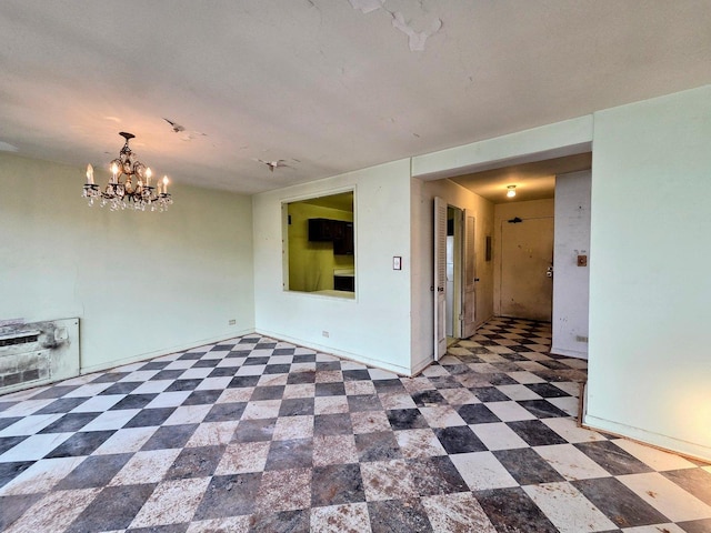 unfurnished room with baseboards, an inviting chandelier, and tile patterned floors