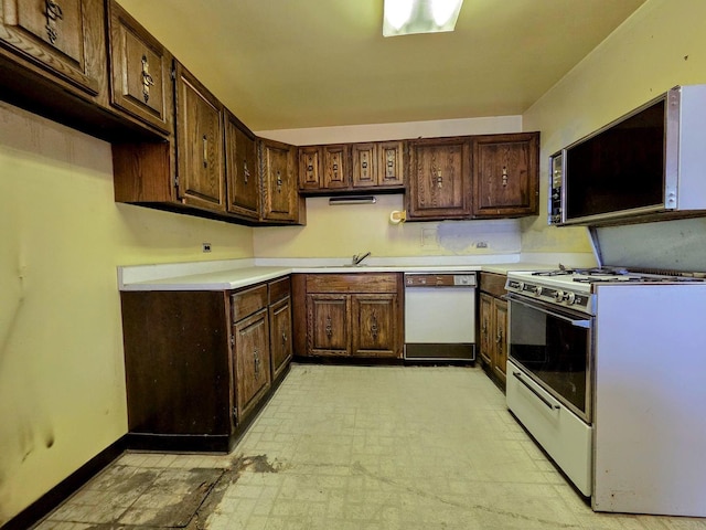 kitchen with white appliances, light countertops, and dark brown cabinets