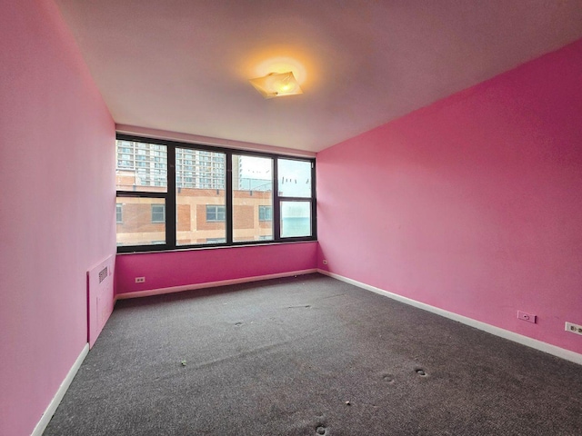 carpeted spare room featuring baseboards