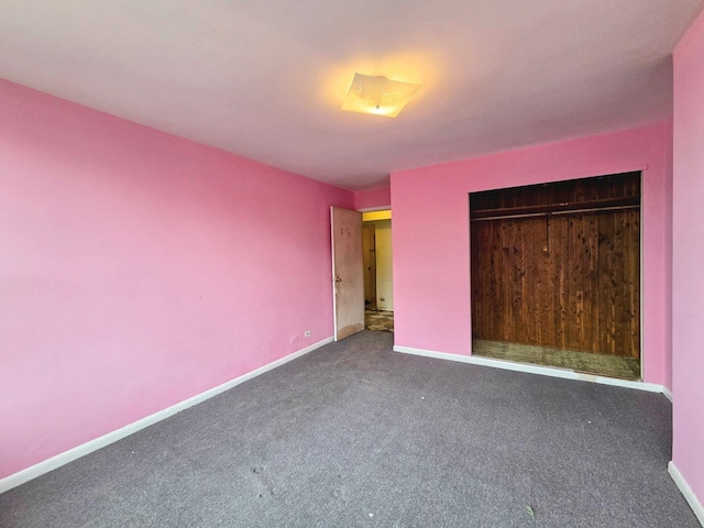 unfurnished bedroom with a closet, carpet flooring, and baseboards