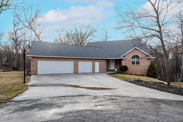 view of front facade with a garage, concrete driveway, roof with shingles, a front lawn, and brick siding