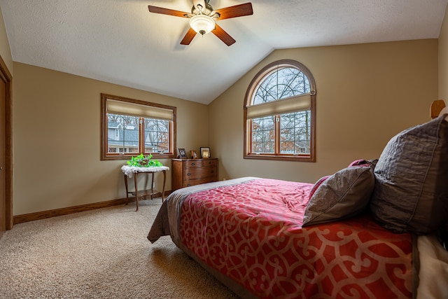 carpeted bedroom with lofted ceiling, multiple windows, a ceiling fan, and baseboards