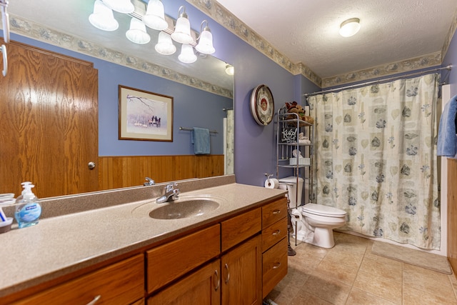 bathroom with a shower with curtain, toilet, a textured ceiling, vanity, and tile patterned flooring