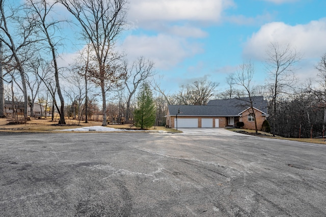 view of front of home with aphalt driveway, brick siding, and an attached garage