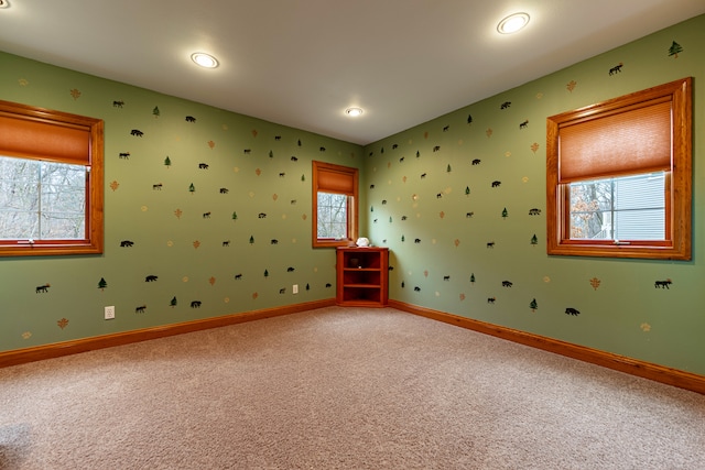 spare room featuring baseboards and light colored carpet