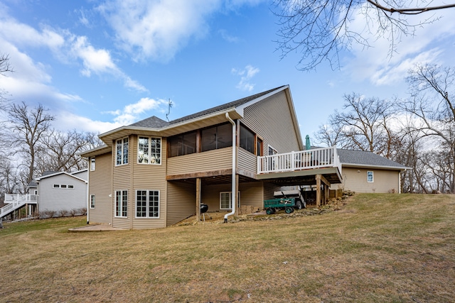 rear view of property featuring a yard, a shingled roof, a wooden deck, and a sunroom