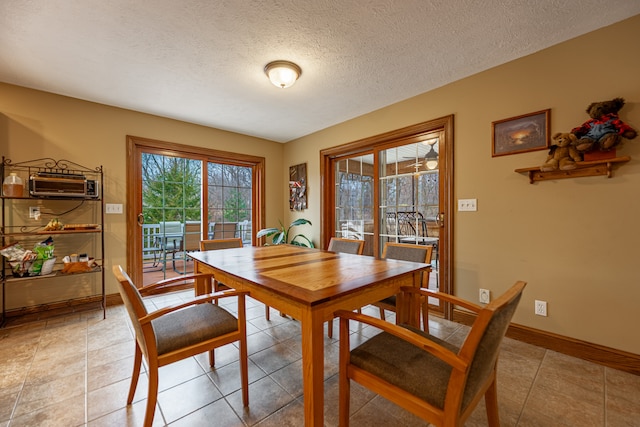 dining room featuring light tile patterned floors, a textured ceiling, baseboards, and an AC wall unit