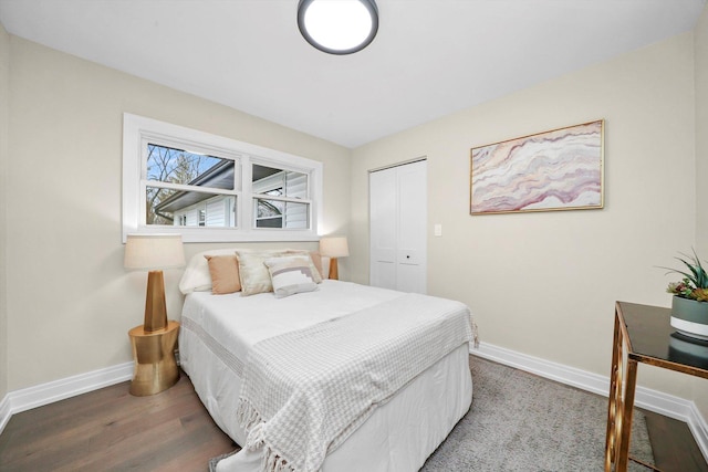 bedroom featuring a closet, baseboards, and wood finished floors