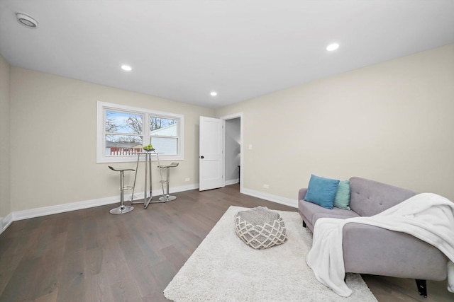 living area with baseboards, wood finished floors, and recessed lighting