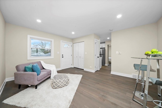 living area featuring baseboards, dark wood-style flooring, and recessed lighting