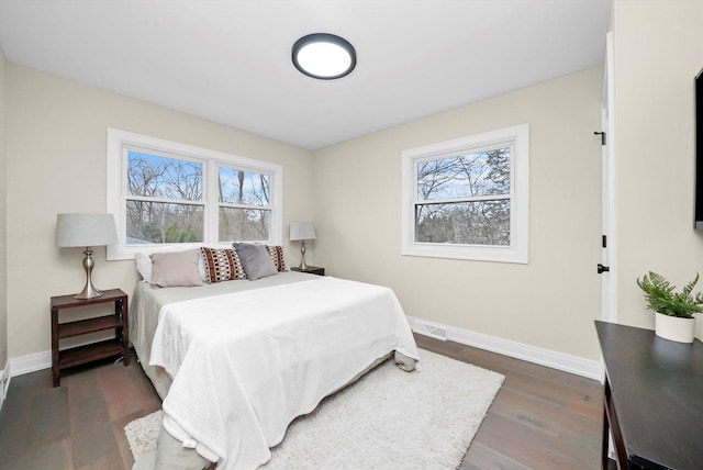 bedroom featuring visible vents, baseboards, and wood finished floors