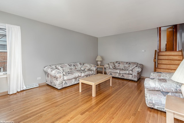 living room featuring stairway, visible vents, light wood-style flooring, and baseboards