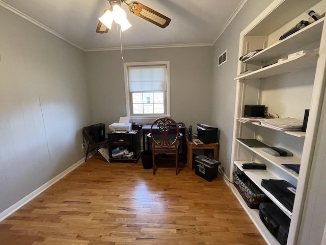 office space with baseboards, ornamental molding, visible vents, and light wood-style floors