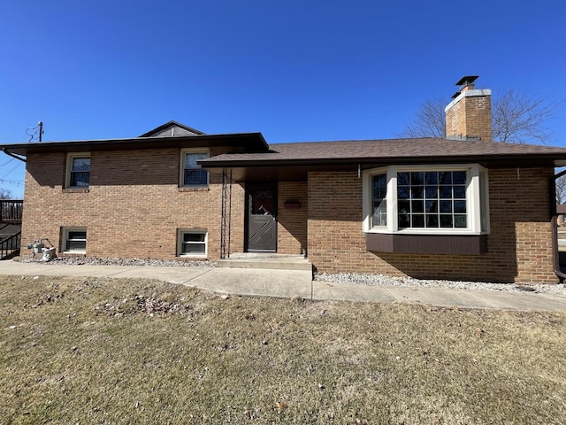 back of house featuring brick siding and a chimney