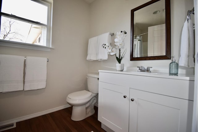 full bath featuring vanity, wood finished floors, visible vents, baseboards, and toilet