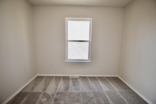 spare room with baseboards and carpet