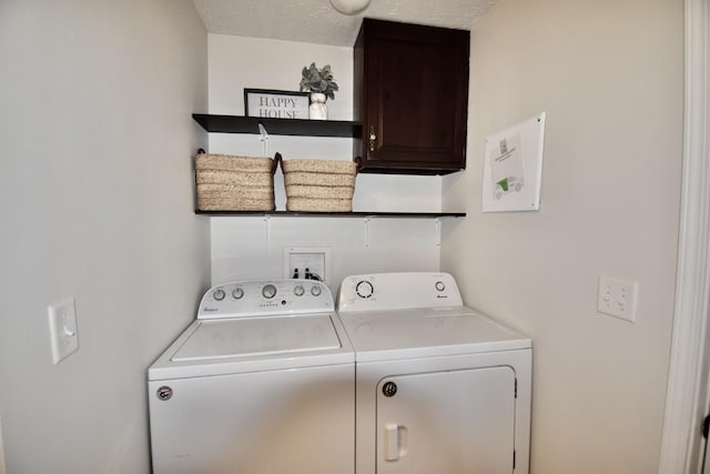 laundry room with cabinet space, independent washer and dryer, and a textured ceiling