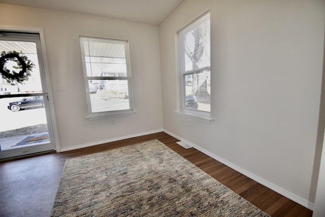 interior space featuring visible vents, baseboards, and dark wood-style flooring