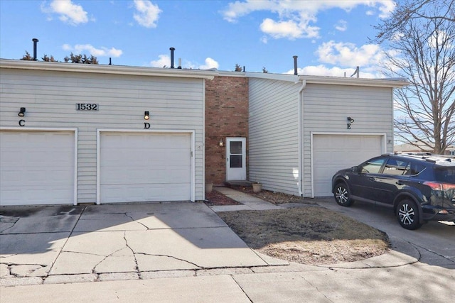 view of front of property featuring a garage, brick siding, and concrete driveway