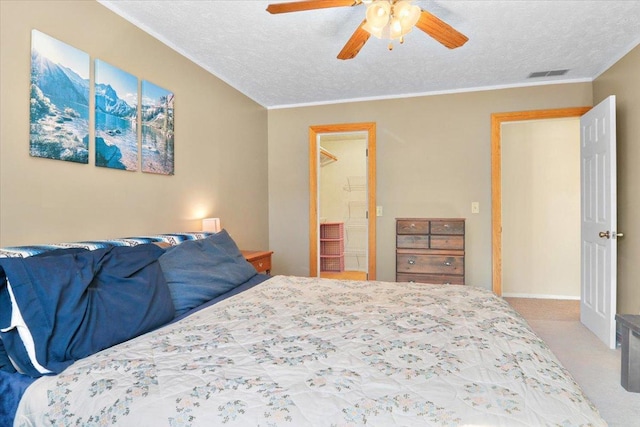 bedroom featuring visible vents, ceiling fan, light colored carpet, ornamental molding, and a textured ceiling