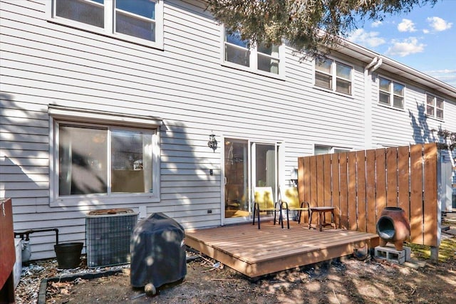 back of property with central AC unit, a deck, and fence