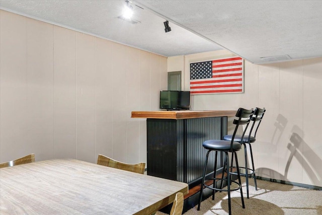 bar featuring a dry bar and a textured ceiling