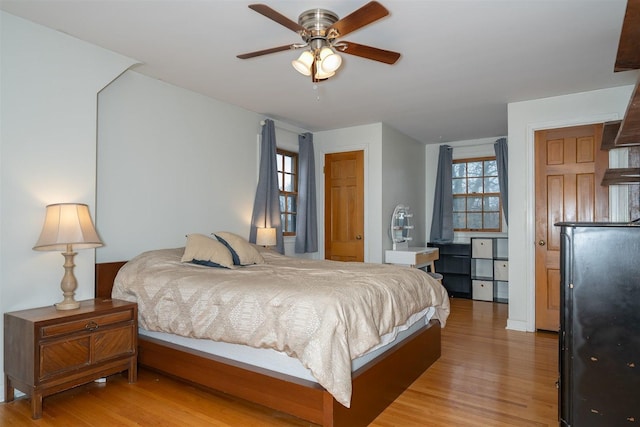 bedroom with multiple windows and light wood finished floors