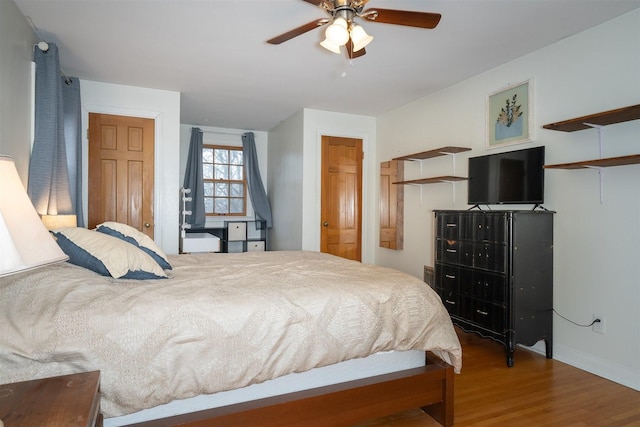 bedroom featuring a ceiling fan, baseboards, and wood finished floors