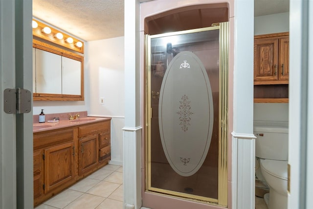 bathroom featuring a sink, a stall shower, tile patterned flooring, and a textured ceiling