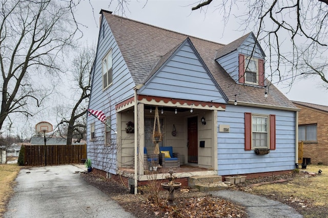 view of front of house with roof with shingles and fence