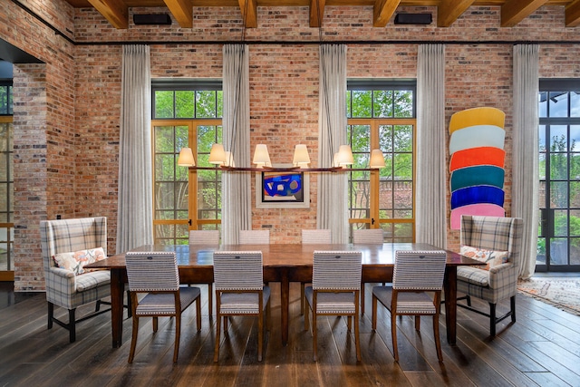 dining space with dark wood-style floors, beamed ceiling, and brick wall