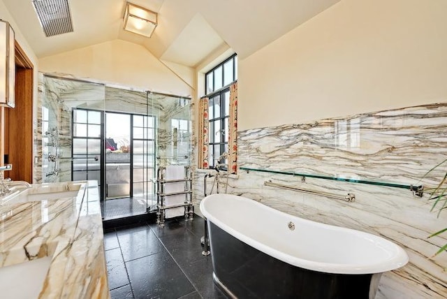 full bathroom with lofted ceiling, a wealth of natural light, visible vents, and tile walls