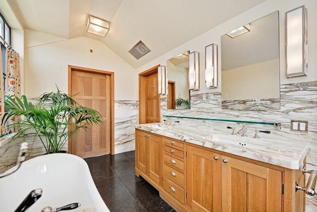 full bath with double vanity, visible vents, a freestanding bath, vaulted ceiling, and a sink