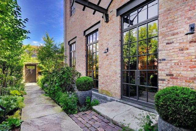 property entrance with brick siding and a gate