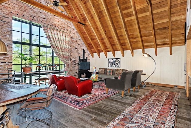 living area featuring a wood stove, wood ceiling, wood finished floors, and beamed ceiling