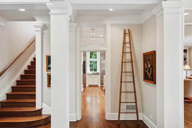 interior space with visible vents, dark wood-type flooring, stairway, ornamental molding, and ornate columns