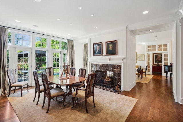 dining room with recessed lighting, wood finished floors, and a high end fireplace