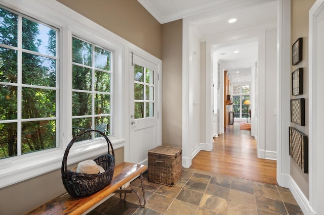 doorway with baseboards, crown molding, and stone finish floor