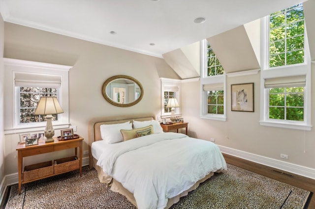 bedroom featuring wood finished floors, crown molding, baseboards, and visible vents