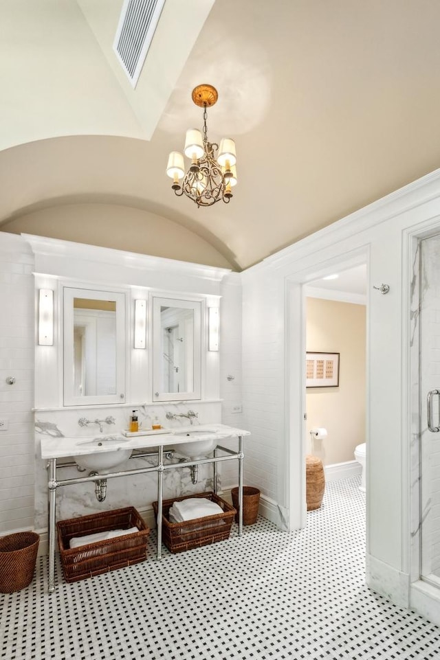 full bath featuring visible vents, a stall shower, a sink, double vanity, and lofted ceiling