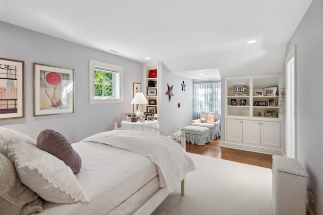 bedroom with recessed lighting and wood finished floors