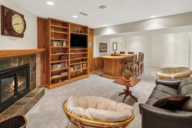 interior space featuring visible vents, baseboards, a tiled fireplace, carpet flooring, and recessed lighting