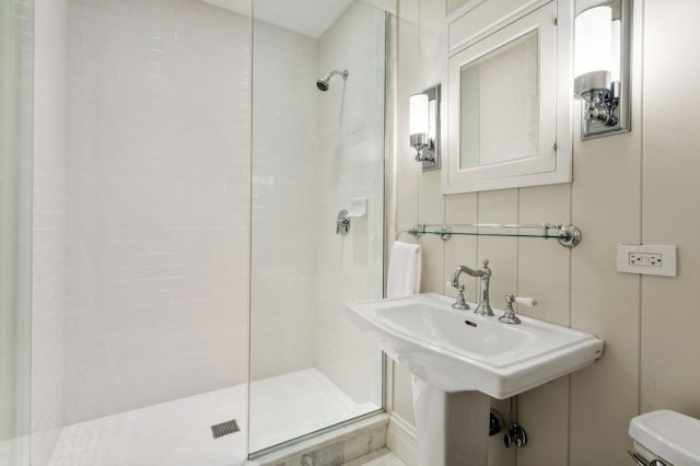 full bathroom with a sink, toilet, and tiled shower