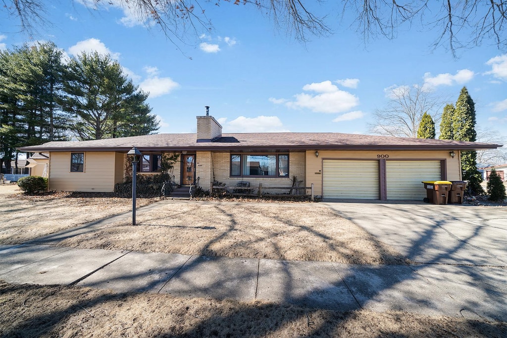 ranch-style house with driveway, a chimney, and an attached garage