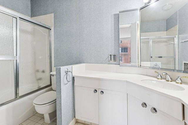 bathroom featuring enclosed tub / shower combo, toilet, tile patterned floors, and vanity