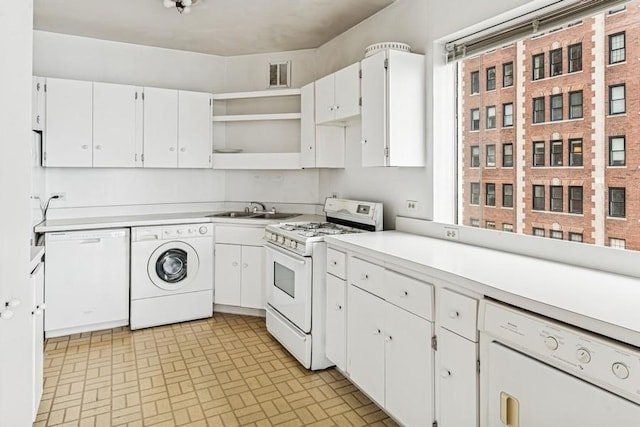 kitchen featuring visible vents, white cabinets, white appliances, washer / clothes dryer, and a sink