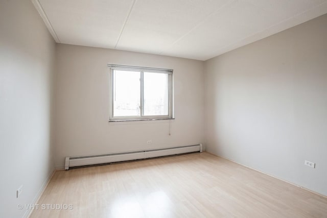 unfurnished room featuring a baseboard radiator and wood finished floors